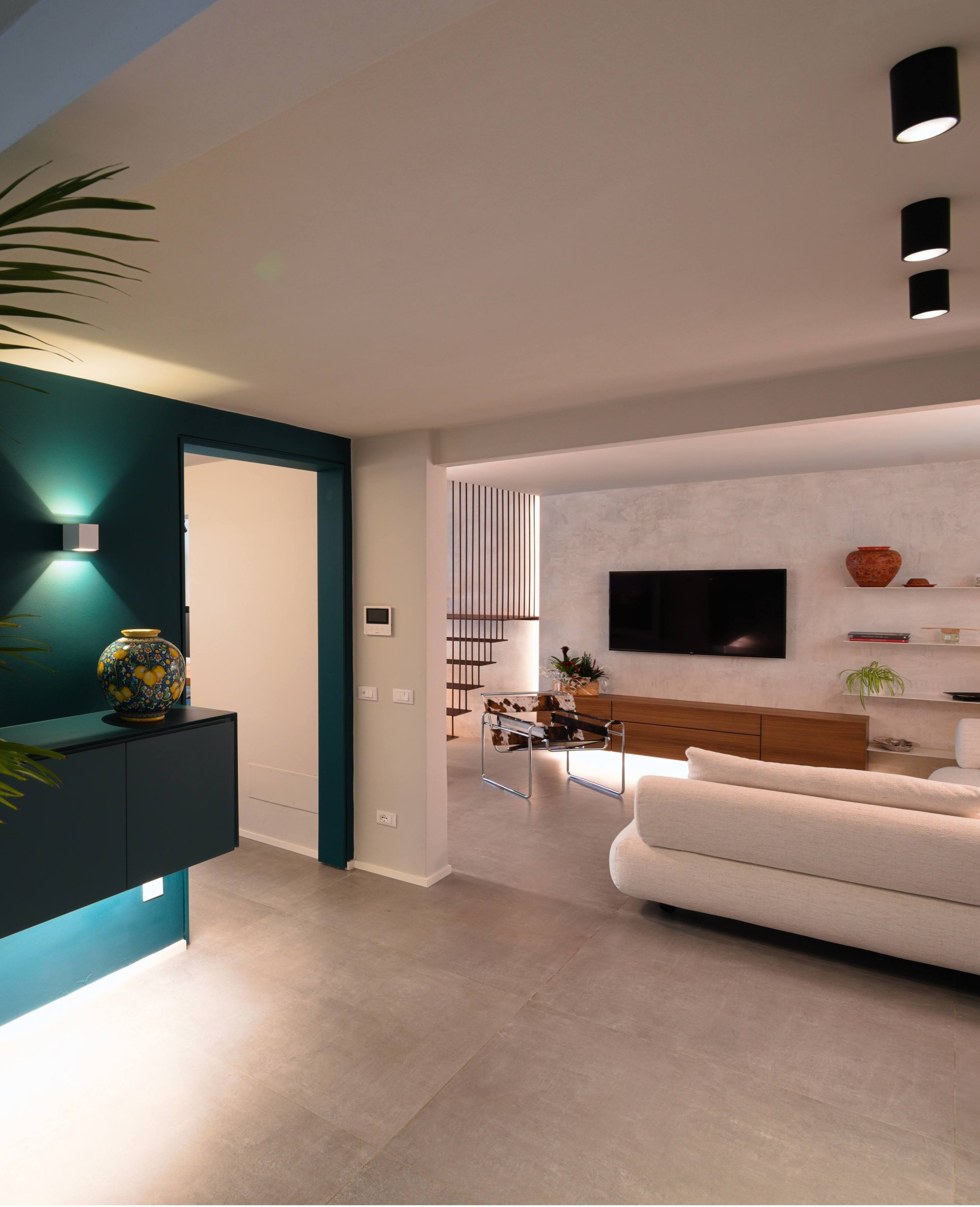 Ingresso Open Space con Parete Ottanio e Living Moderno – MICHELE VOLPI STUDIO INTERIOR DESIGN ngresso moderno con parete d'accento ottanio, mobile sospeso retroilluminato e vista sul living open space con scala architettonica.