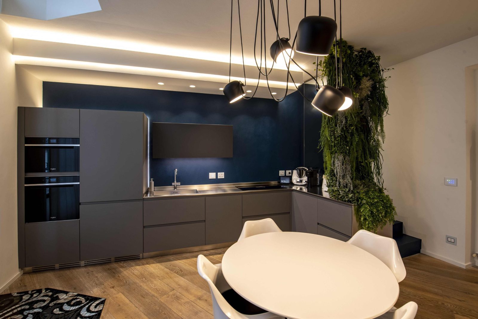 immagine di una cucina personalizzata e su misura, caratterizzata da un piano in acciaio e una parete in microresina blu